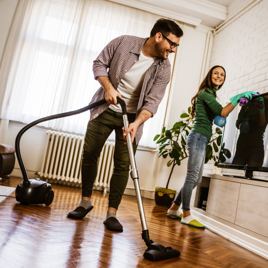 Glückliches Paar putzt die Wohnung