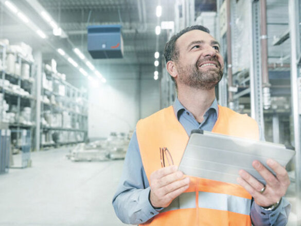 mitarbeiter schaut hoch zu industrielle luftreiniger, prüfen