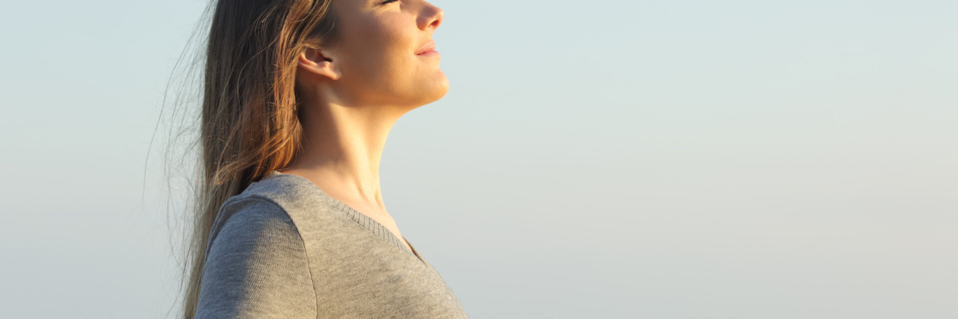 Side view portrait of a relaxed woman breathing fresh air on the beach