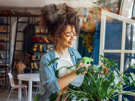Happy and healthy woman taking care of her plants and breathing clean air